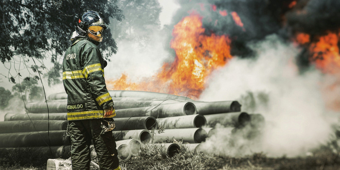 Photo of a Macon County Firefighter standing within a burning forest.